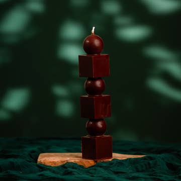 Stacked wooden candle holder with a dark background