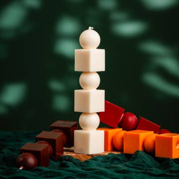 Stack of white, brown, and orange cylindrical blocks on a dark green background