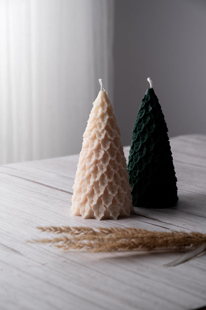 Two cone-shaped candles, one beige and one green, on a light wooden surface with a blurred background.