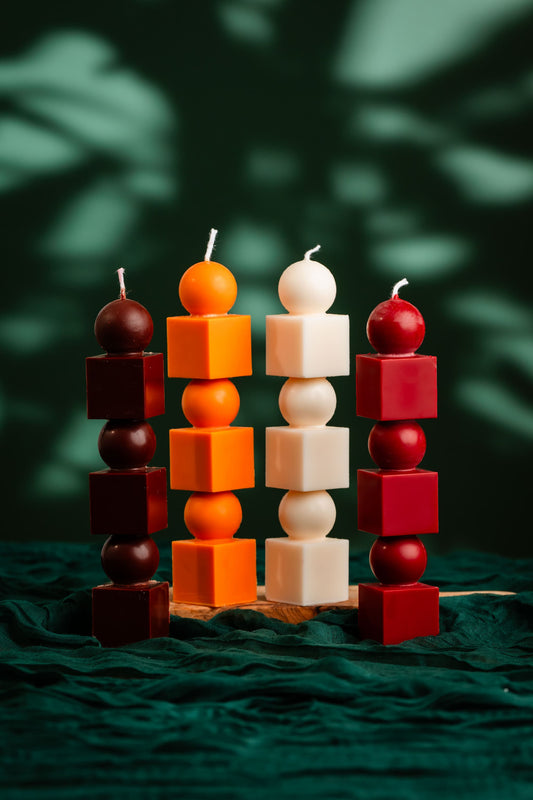 Colorful candle stacks on a dark green fabric background